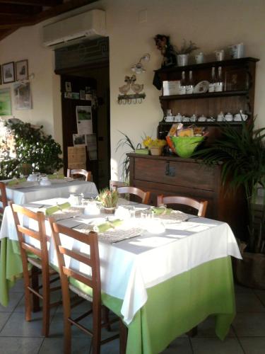 a dining room with a table with a white and green table cloth at Hostaria Da Ivan in Roccabianca