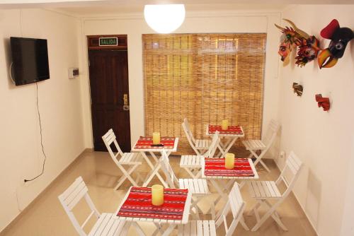 a dining room with chairs and tables and a television at Hotel Velero Centro in Iquique