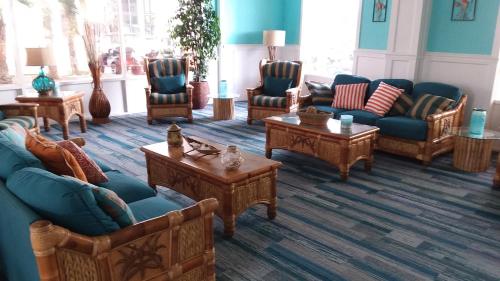 a living room with couches and tables at Fountain Beach Resort - Daytona Beach in Daytona Beach