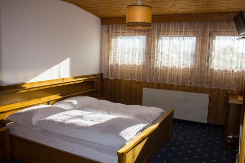um quarto com uma cama num quarto com janelas em Gasthof Paul em Naz-Sciaves