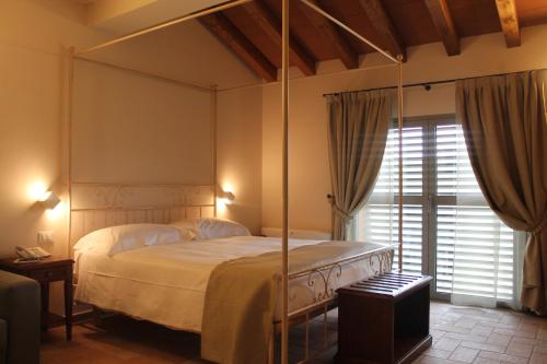 a bedroom with a canopy bed and a window at Agriturismo Ben Ti Voglio in Bologna
