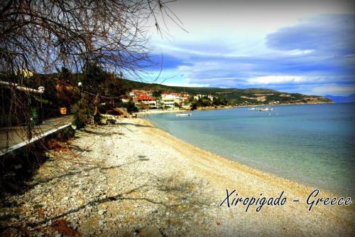 a sandy beach with boats in the water at Oniro Apartments in Xiropigado