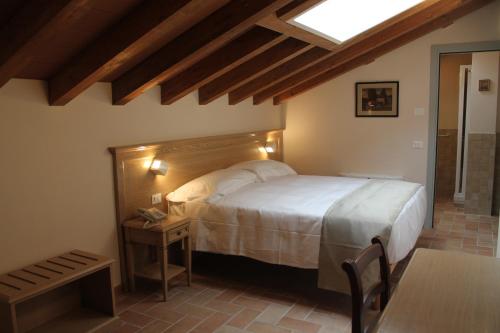 a bedroom with a bed with a wooden headboard and a table at Agriturismo Ben Ti Voglio in Bologna
