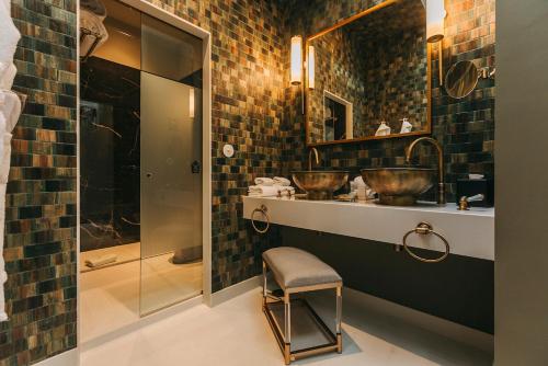 a bathroom with two sinks and a glass shower at Torel 1884 Suites & Apartments in Porto