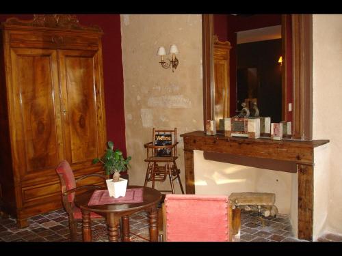 a living room with a table and a fireplace at Le Relais du Lyon d'Or in Angles-sur-lʼAnglin