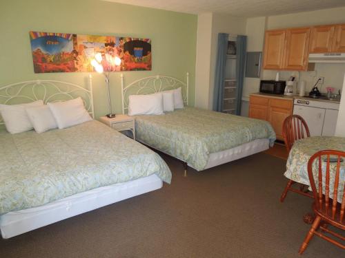 a hotel room with two beds and a kitchen at Sifting Sands Motel in Ocean City