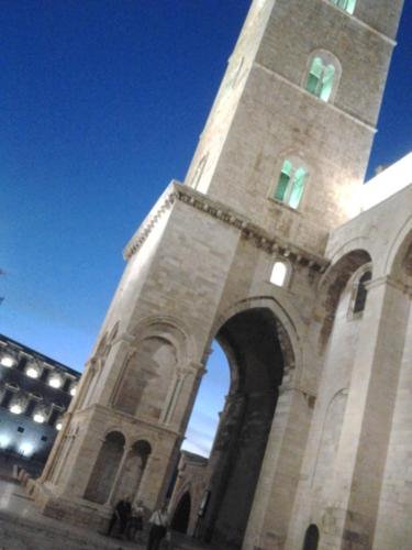a building with a clock tower with an entrance at Arco' B&B Trani Cattedrale in Trani