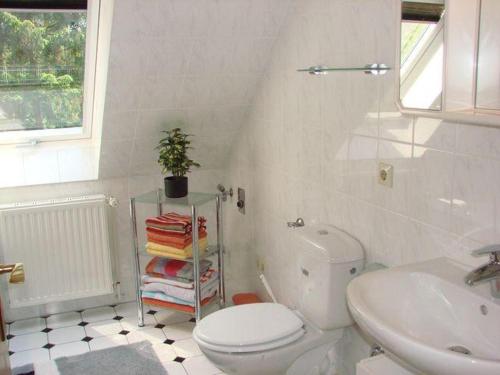 biała łazienka z toaletą i umywalką w obiekcie Fewo Karin Tiedemann w mieście Hechthausen