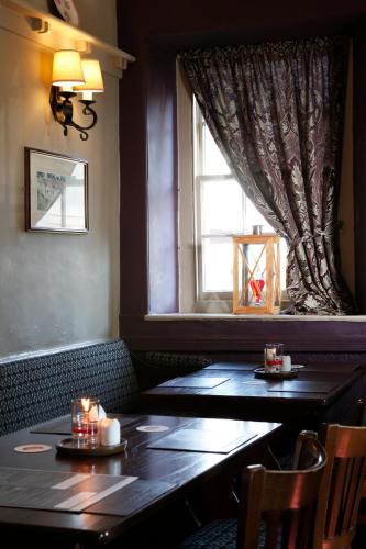 a dining room with two tables and a window at The Peacock in Bakewell