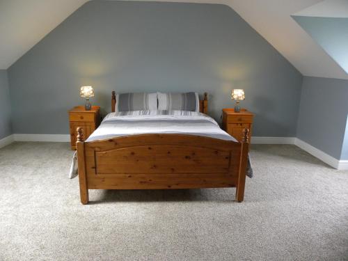 Glanbannoo UpperにあるOrchard lodge Bantryのベッドルーム1室(木製ベッド1台、ナイトスタンド2台付)