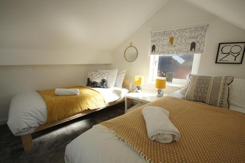 a bedroom with two beds and a window at Loft Style Apartment for 4, 1 Broadhurst Court, close to town, station & hospital in Stockport