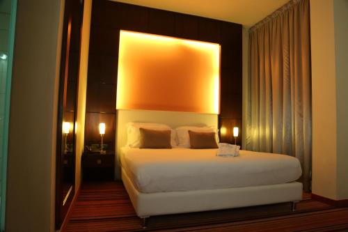 a bedroom with a large white bed with a large mirror at Monte Mare Hotel in Jounieh