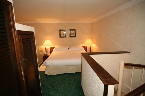 a hotel room with a white bed and green carpet at Aldrovandi Residence City Suites in Rome