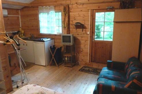 a living room with a blue couch and a kitchen at Beau Site Guimauve et Vieilles Dentelles in Royères-Saint-Léonard