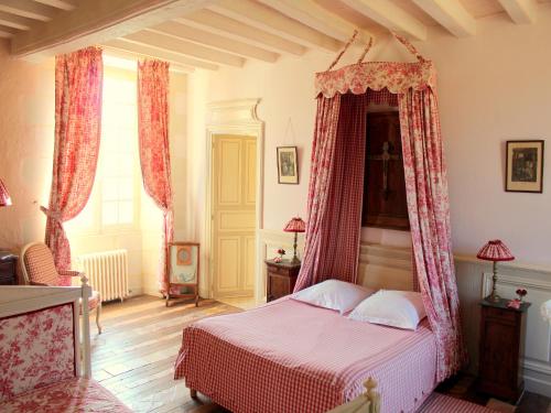 a bedroom with a bed with red drapes at Château De Chambiers in Durtal