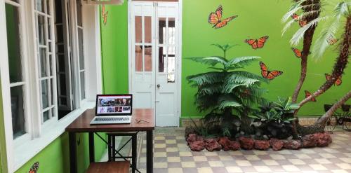 a laptop computer on a table in a room with butterflies on the wall at Casa Mayela Guest House in San José