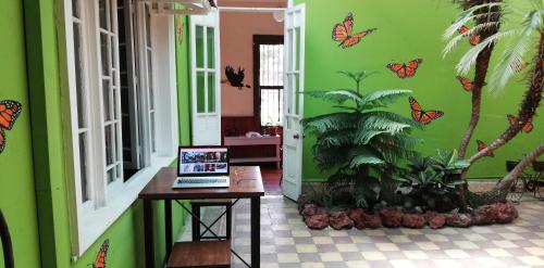 a laptop on a table in a room with butterflies on the wall at Casa Mayela Guest House in San José