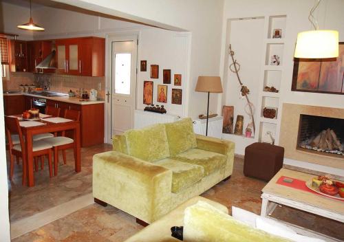 a living room with a couch and a table and a kitchen at Eirini's House Corfu in Kynopiástai