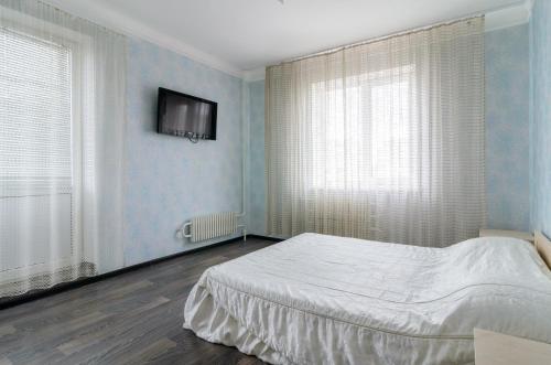 ein Schlafzimmer mit einem Bett und einem TV an der Wand in der Unterkunft The Modern Home пр М Лушпы 22 in Sumy