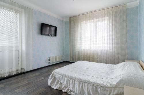a bedroom with a bed and a tv on the wall at The Modern Home пр М Лушпы 22 in Sumy