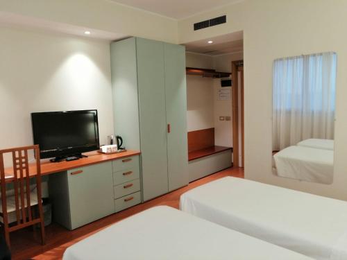 a room with a bed and a tv and a bedroom at Best Western Air Hotel Linate in Segrate
