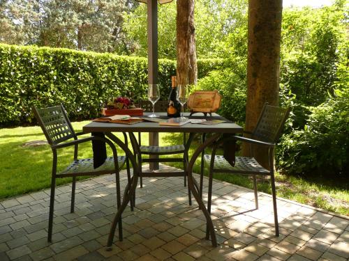 a table with two chairs and a bottle of wine at La Meridiana Affittacamere in Colorno