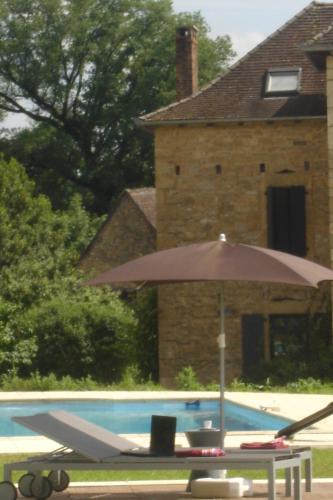 an umbrella sitting next to a swimming pool at Hotel La Bastie d'Urfé in Naussac