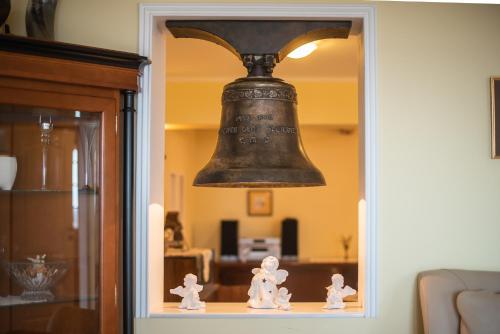 a bell hanging over a shelf in a room at Villa Zupan with Hot Tub in Škocjan