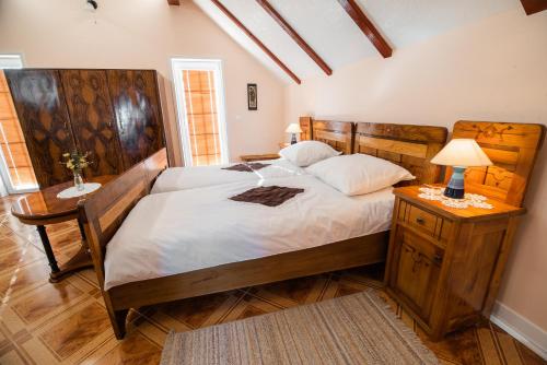 a bedroom with a large bed with a wooden headboard at Villa Zupan with Hot Tub in Škocjan