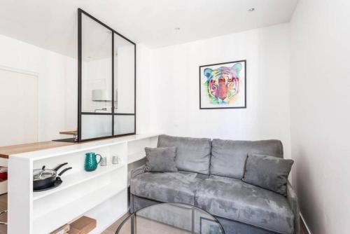 un salon avec un canapé et un miroir dans l'établissement Modern studio perfectly equipped and renovated, à Paris