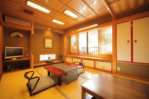 a living room with a table and a tv at Morizuya in Toyooka
