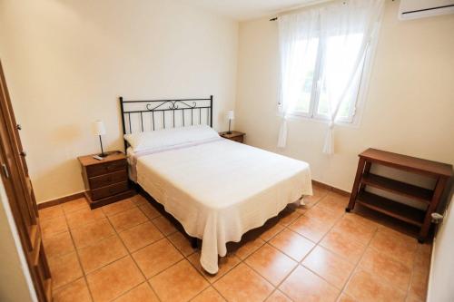 a bedroom with a white bed and a window at Can Furnet in Sant Jordi