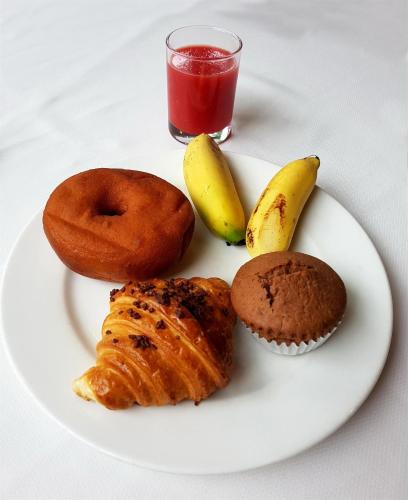 a plate of food with a donut and muffins and a drink at Mequfi Beach Resort in Mecúfi