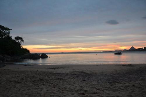 a sunset on a beach with the ocean at Pousada Barlavento in Iriri