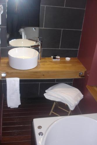 a bathroom with a sink and a toilet and a tub at Hotel La Bastie d'Urfé in Naussac