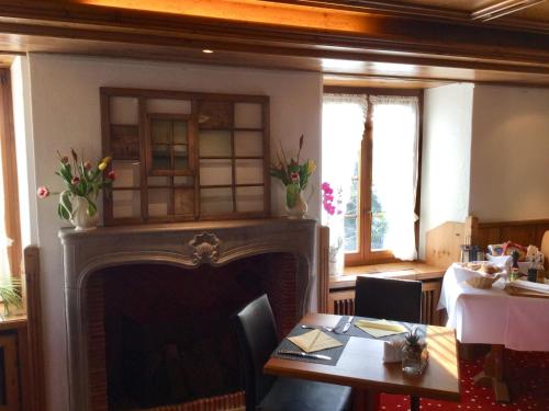 a living room with a fireplace and a table and a dining room at Hotel zum Kreuz in Suhr