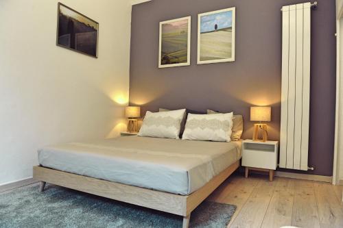 a bedroom with a bed with two lamps and two pictures on the wall at Domus Plaza in Florence