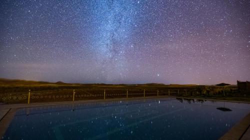a starry night with a swimming pool and the milky way at Ecolodge l'île de Ouarzazate in Ouarzazate