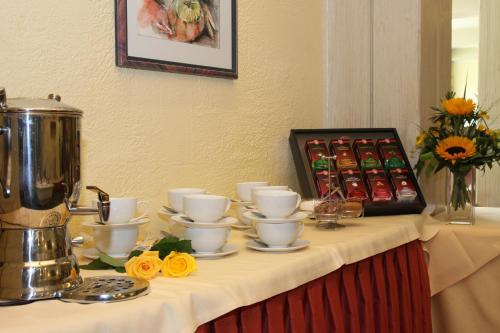 a table with cups and saucers and drinks on it at Sporthotel Walliser in Hirschegg
