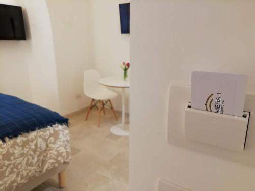 a room with a bed and a table with a box at La Volta Buona in Matera