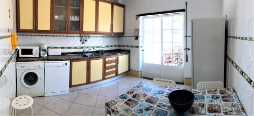 a kitchen with a table and a washing machine at Altura da Maré - Apartamento Duna in Altura