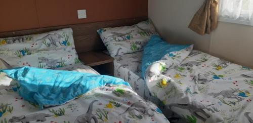 een slaapkamer met 2 aparte bedden en een sprei met olifanten bij crimdon dene holiday park in Hartlepool