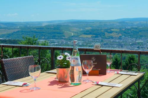 a bottle of wine sitting on a table with wine glasses at Berghotel Kockelsberg in Trier