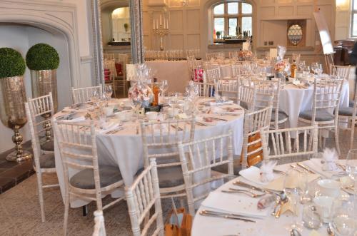 a room full of tables with white chairs and tablesearcher at Weston Hall in Stafford