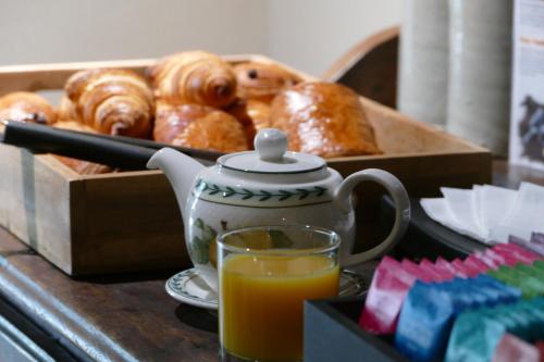 a box of donuts and a glass of orange juice at Logis Hotels Le Champalud Restaurant La Citadelle in Champtoceaux