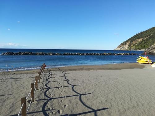 a sandy beach with a fence and the ocean at Casa Anna in Moneglia