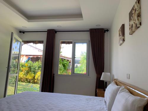 a bedroom with a bed and a large window at Làng biển Homestay in Quang Ngai
