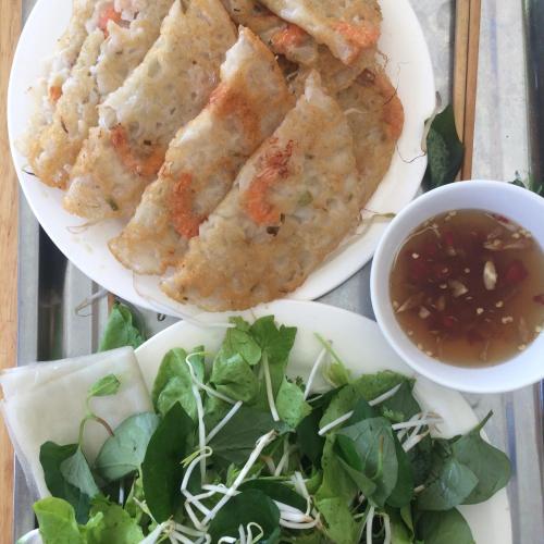 two plates of food with a salad and dipping sauce at Làng biển Homestay in Quang Ngai