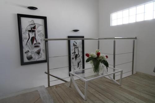a room with a glass table with a vase of flowers on it at Albachiara Hotel - Las Terrenas in Las Terrenas