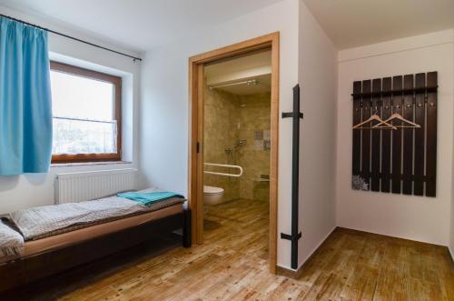 um quarto com um chuveiro e uma cama num quarto em Čičina Tvrdonice penzion, restaurace, vinný sklep em Tvrdonice